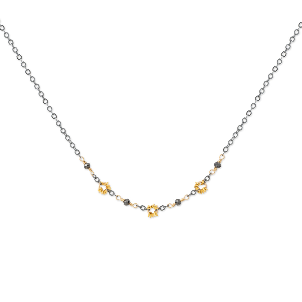 A delicate necklace featuring a fine silver chain with small gold and black beads, accented by three gold flower-shaped charms in the center, displayed on a clean white background.