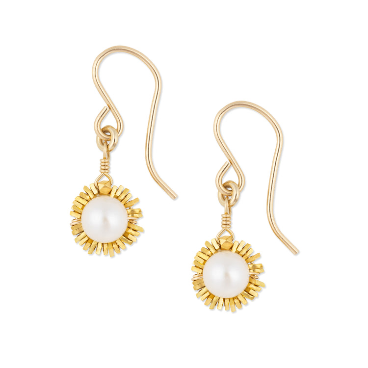 Gold earrings with pearl center on a white background