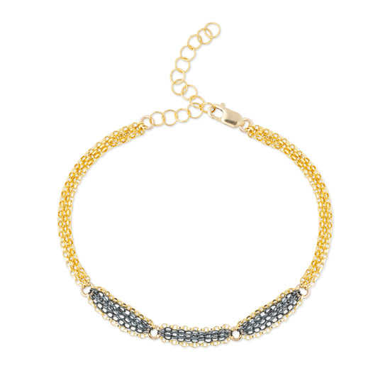 A mixed metal bracelet with a patterned chain of 14K gold-fill and oxidized sterling silver, displayed on a white background.