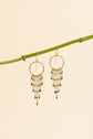 Emerald fringe earrings hanging on a branch