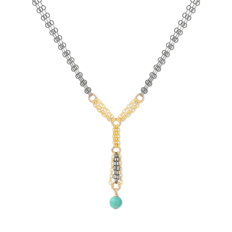 A Y-shaped necklace featuring a gold and silver chain design with a turquoise bead pendant, shown on a plain white background.
