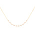 Delicate gold necklace with small garnet beads on a white background
