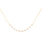 Delicate gold necklace with small garnet beads on a white background