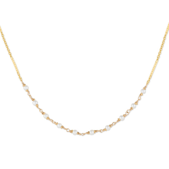 Gold necklace with small pearls on a white background