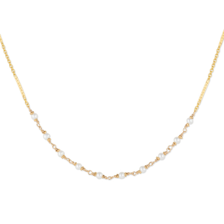 Gold necklace with small pearls on a white background