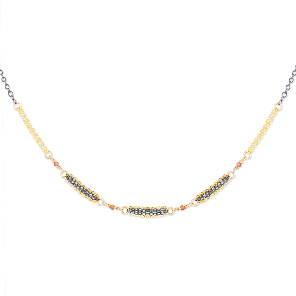Mixed metal necklace with natural faceted garnets on a white background
