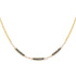 Gold necklace with black and white bead details on a white background