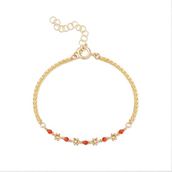 A gold-colored bracelet featuring small red coral beads and gold accents, with a chain clasp.
