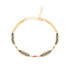 Gold bracelet with oxidized chain details and red garnet  beads on a white background