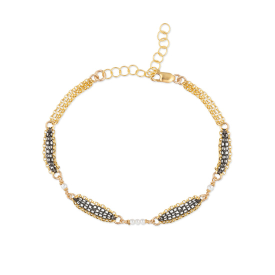 Gold bracelet with oxidized sterling silver chain and pearls on a white background