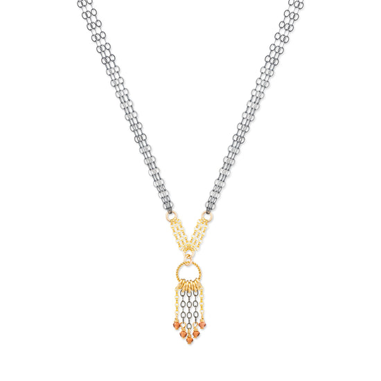 Necklace with a gold and oxidized silver pendant with garnet stones on a white background