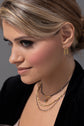 Model is wearing Gen Gold post earrings and layered mixed metal necklaces 