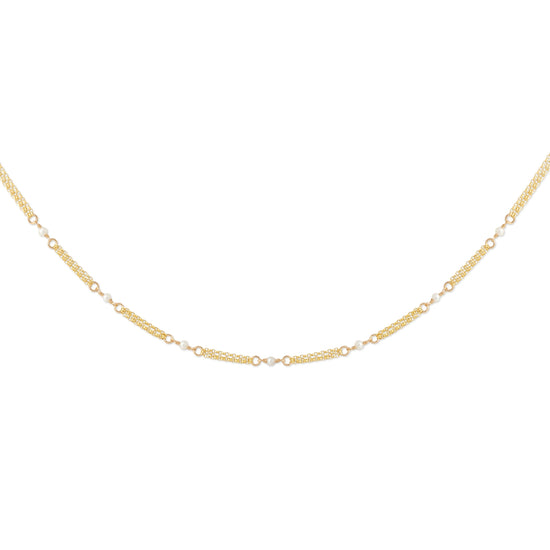 A delicate gold chain necklace with alternating textured oval links and small round clear stones, displayed in a curved shape against a plain white background.