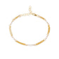 A delicate gold chain anklet featuring alternating small white pearl beads and textured gold spacer links, displayed on a clean white background.