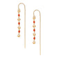 A pair of gold-colored threader earrings featuring red coral beads and gold accents, displayed against a white background.
