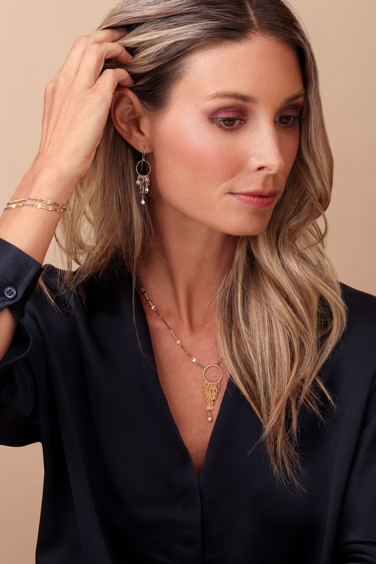 Model with hand in hair wearing the mixed metal styles, Seema, Samira and Saira