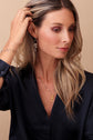 Model with hand in hair wearing the mixed metal styles, Seema, Samira and Saira
