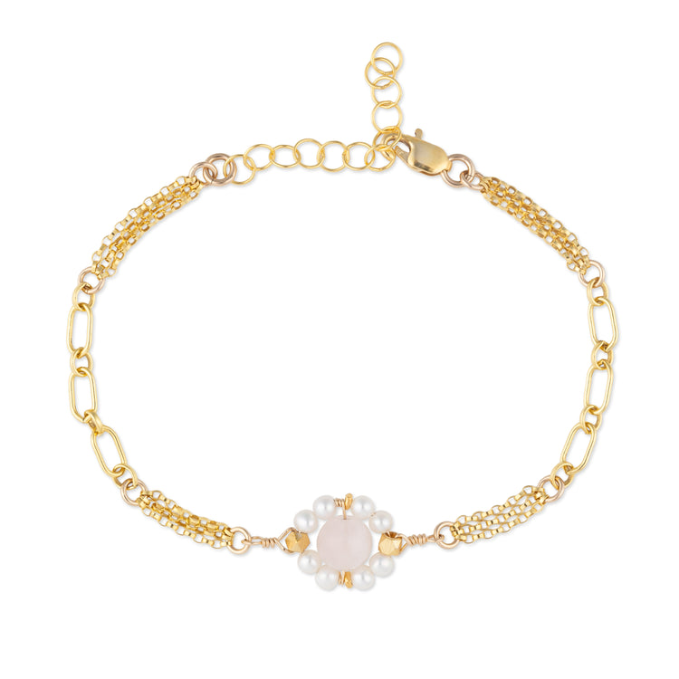 Gold bracelet with pearl and rose quartz beads on a white background