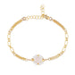 Gold bracelet with pearl and rose quartz beads on a white background