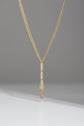 Mixed metal Y necklace with sunstone drop and accent beads hanging on a gray backgroud