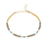 A gold chain bracelet featuring three horizontal rows of oxidized silver chain, accented with turquoise blue beads, displayed on a clean white background.